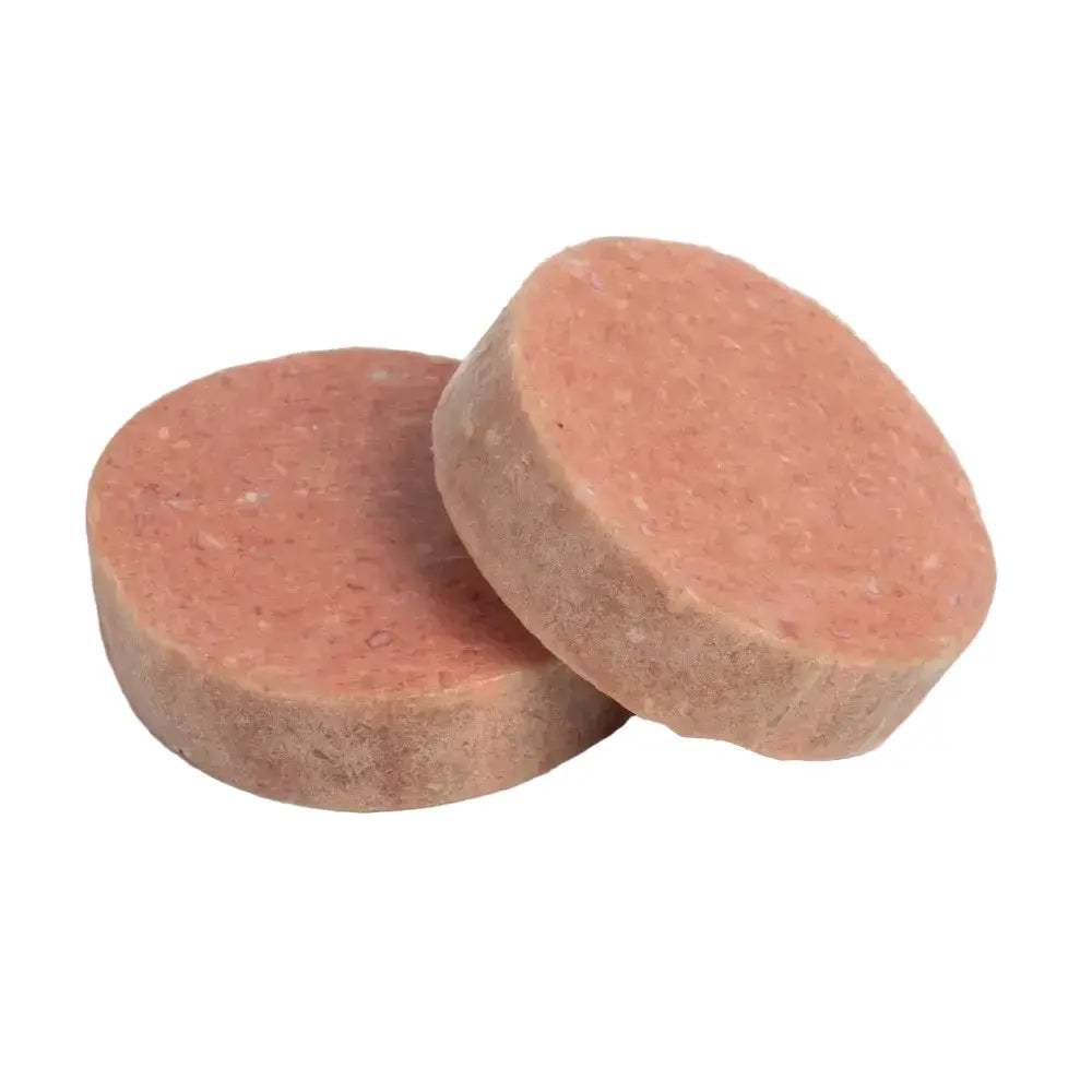 Two pinkish circular patties on a white background